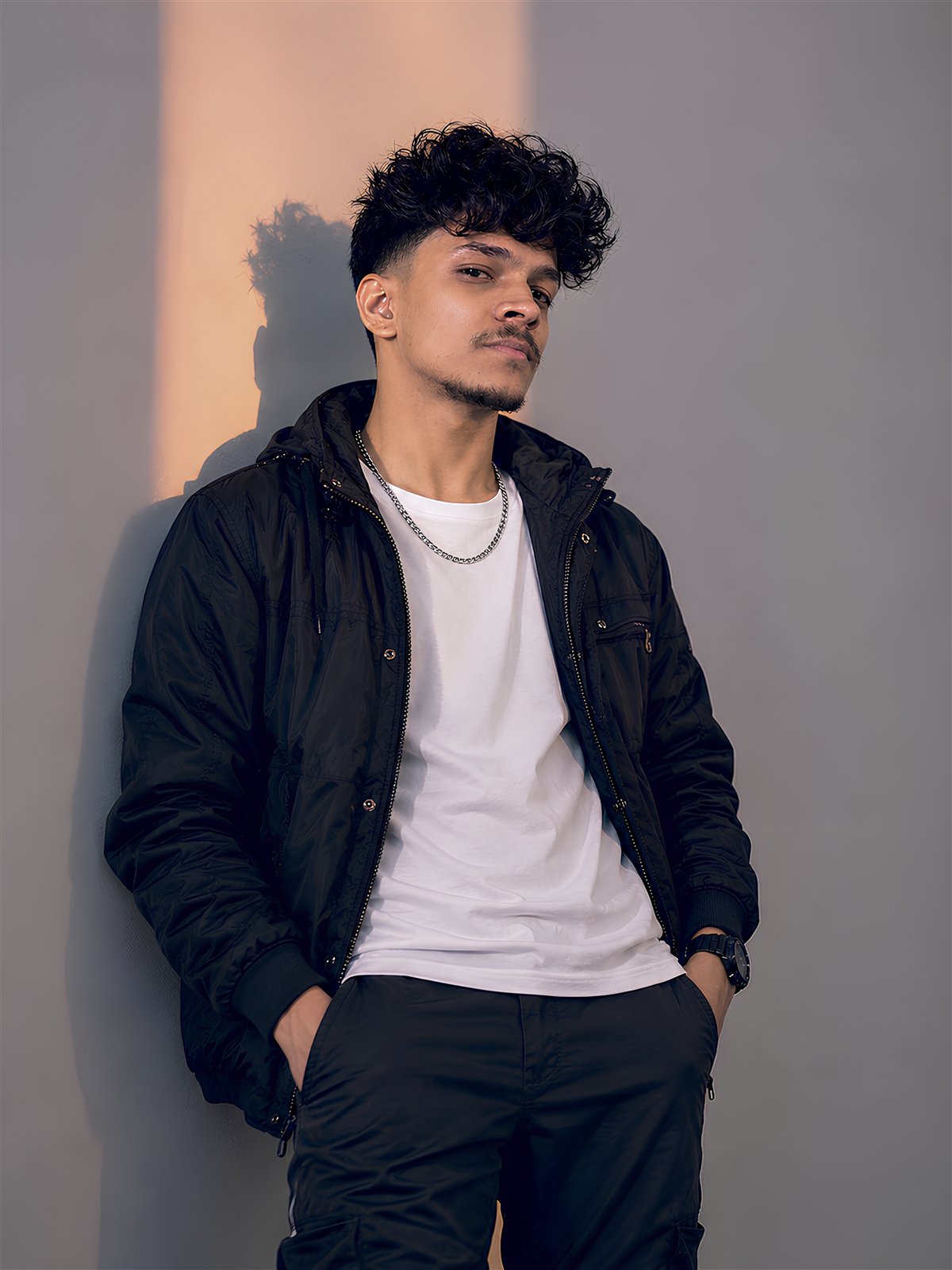 DJ S33K3R in a seated warm-toned portrait